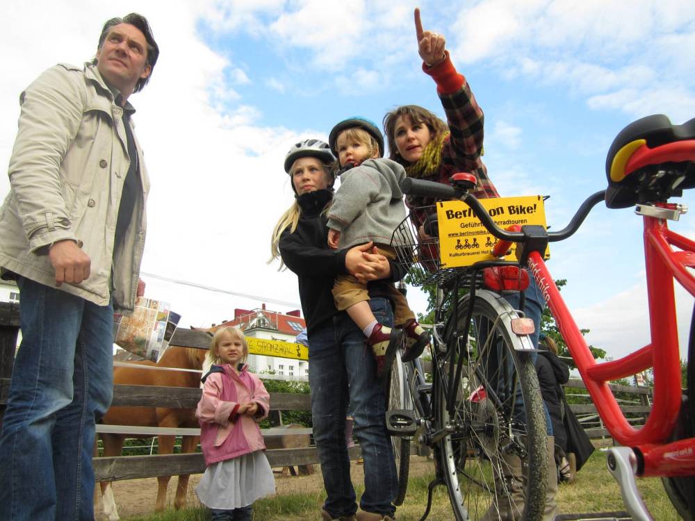 a group of people standing next to a bicycle