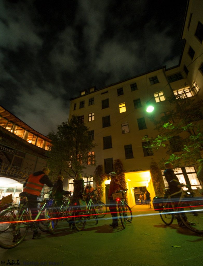 a group of people walking on a city street at night