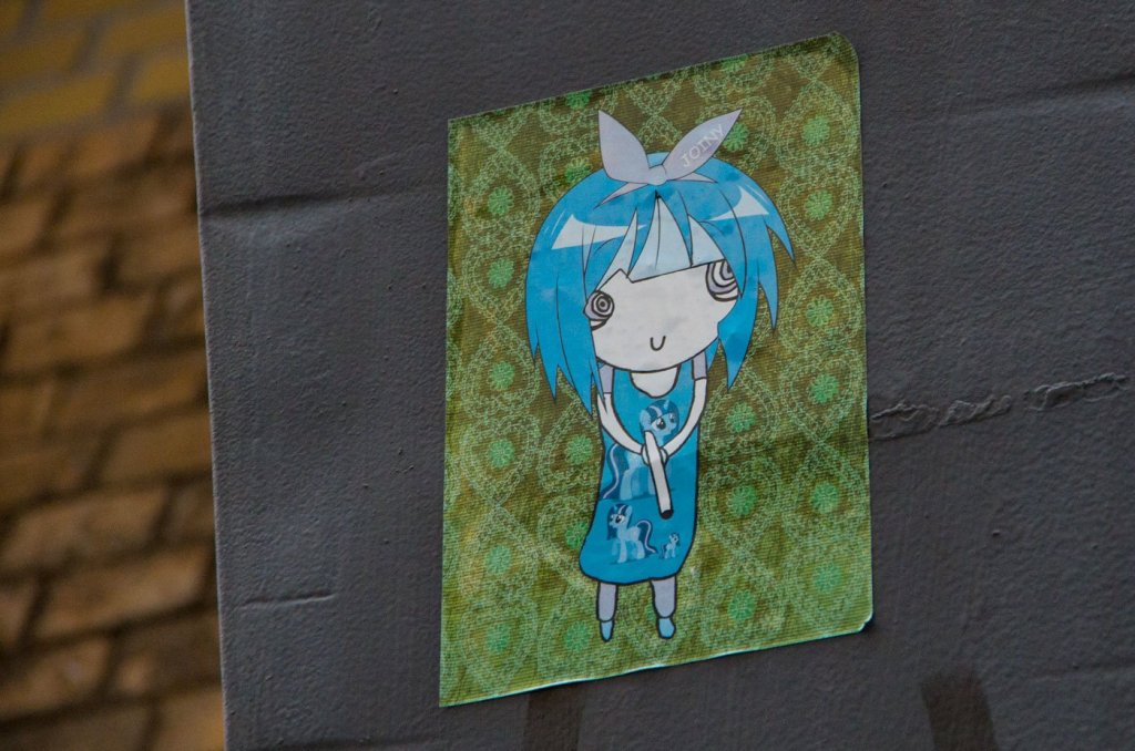Street Art in Berlin Mitte: Noch ein süßes Killer-Manga-Mädchen mit Drogen im Kopf und einer Waffe in der Hand.