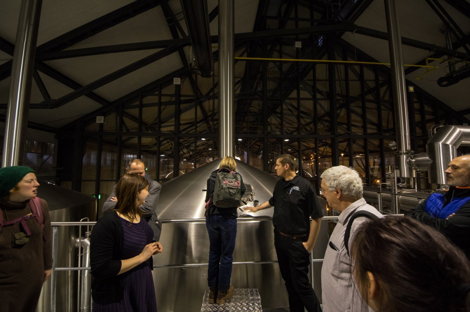 Besucher blicken in den Braukessel bei Stone Brewing Berlin