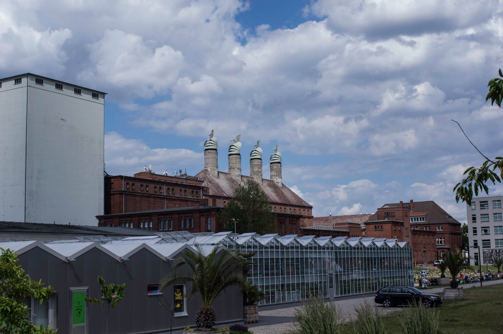 Gewächshäuser und Industriebauten mit Schornsteinen auf dem Gelände der alten Malzfabrik in Tempelhof.