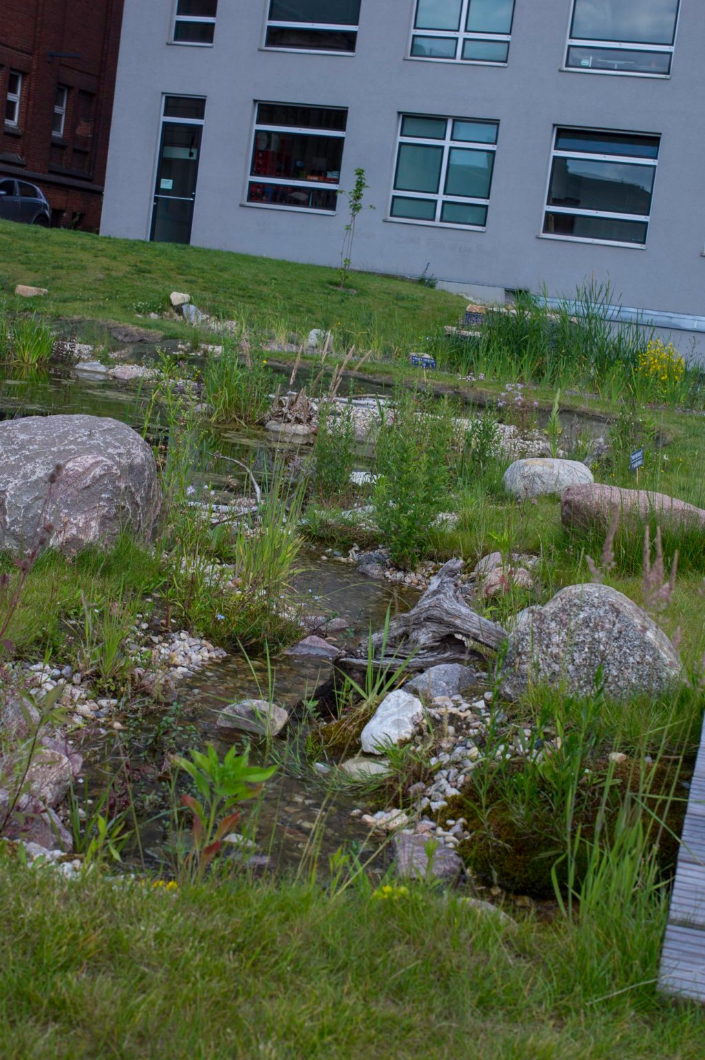a large brick building with grass in front of a house