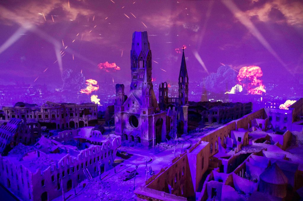 Lichtprojektionen ergänzen die Modelle und kreieren eine teils bedrückende Stimmung wie hier bei dieser Darstellung einer Bombennacht an der schon getroffenen Kaiser-Wilhelm-Gedächtniskirche.