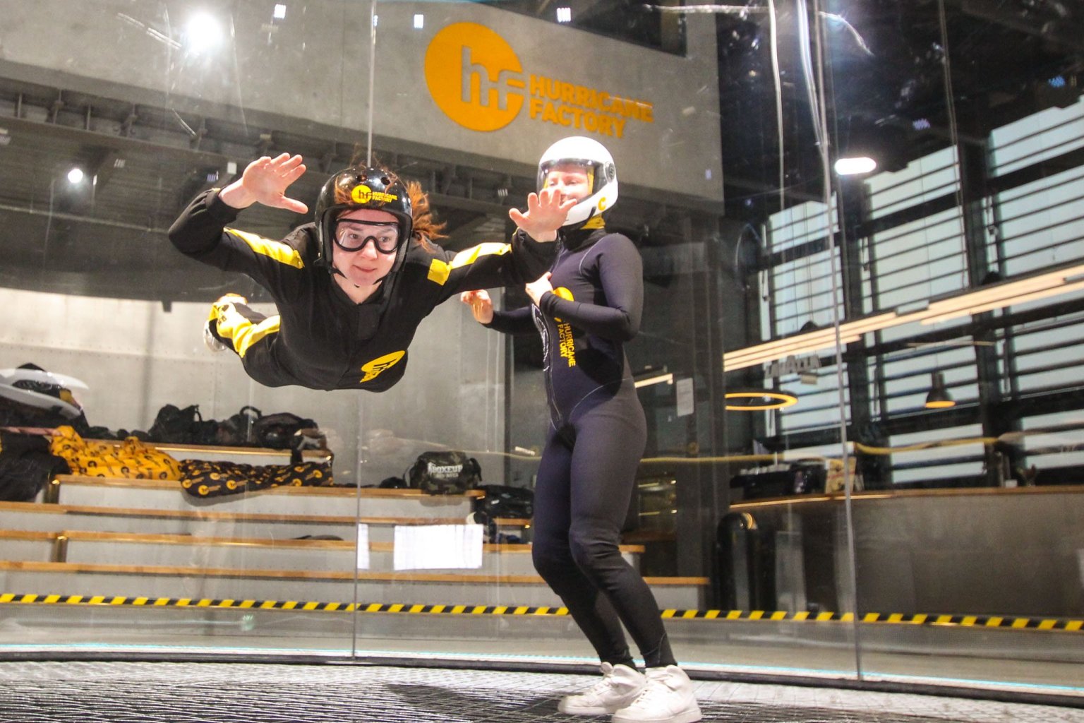 Two women in a wind tunnel in Berlin, one holding the other
