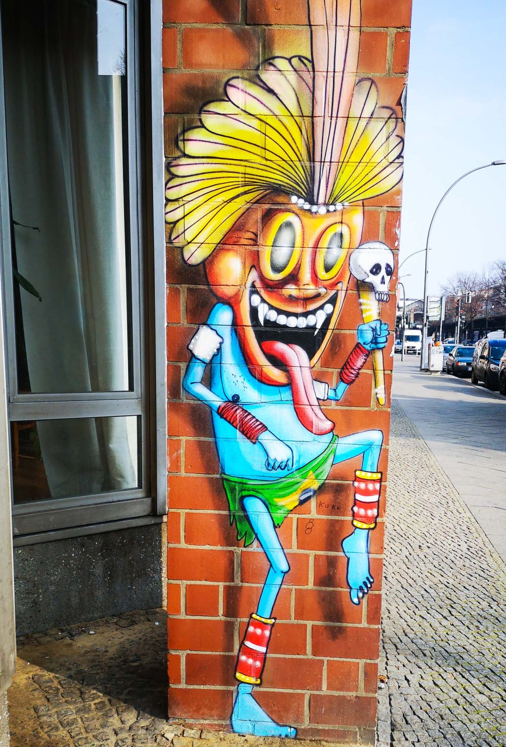 Daincing priest with a skull scepter by Cranio across from the Urban Nation museum in Berlin.