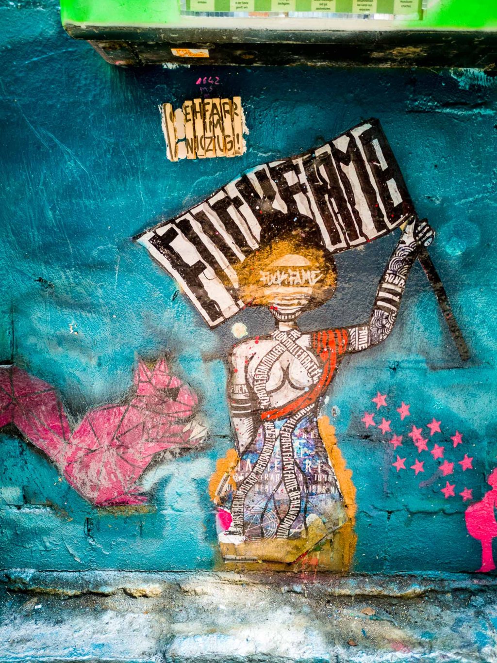 Paste-Up of a geisha holding up a flag saying "Fuck Fame" by artists Ron Miller.