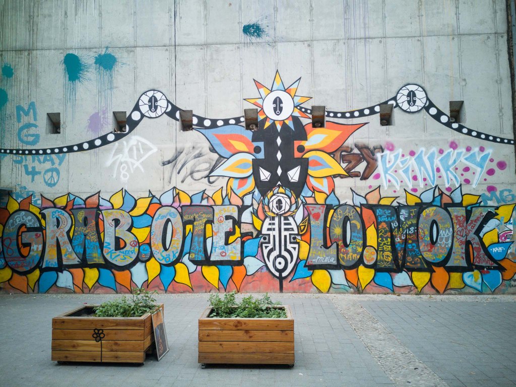 Graffiti piece in Berlin Neukölln with tribal patterns and a hippie-style font.