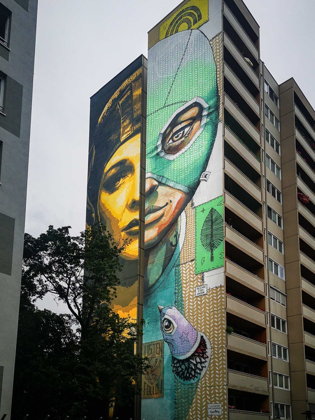 Diptych on a giant wall in Berlin Tegel; one side showing a female pilot, the other a female Luchadora (wrestler).