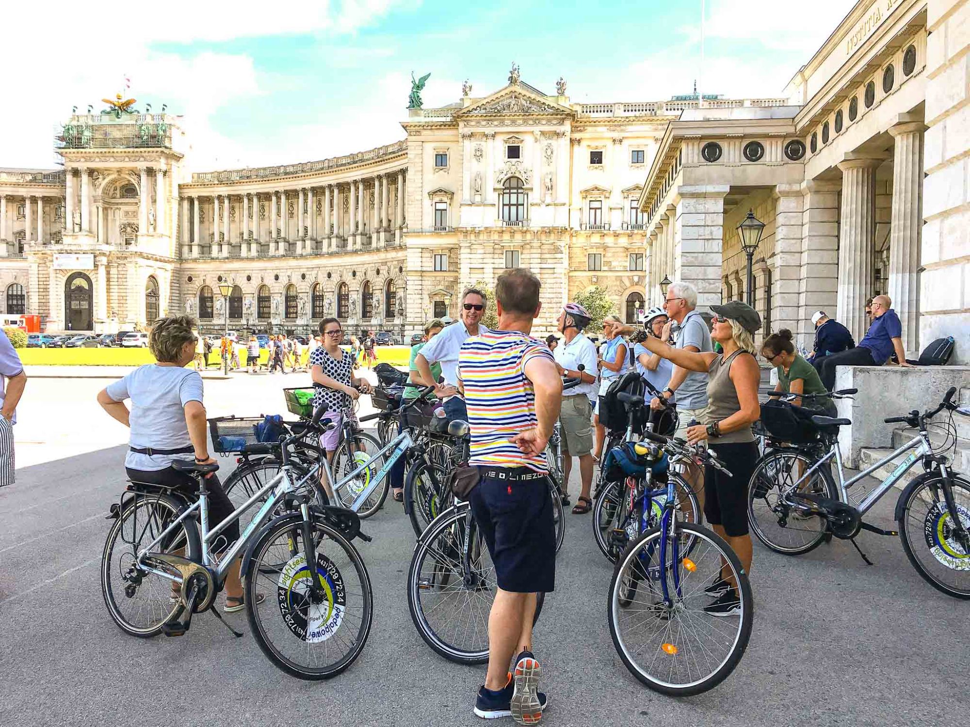 Neue-Hofburg1 a group of people standing in front of a bicycle