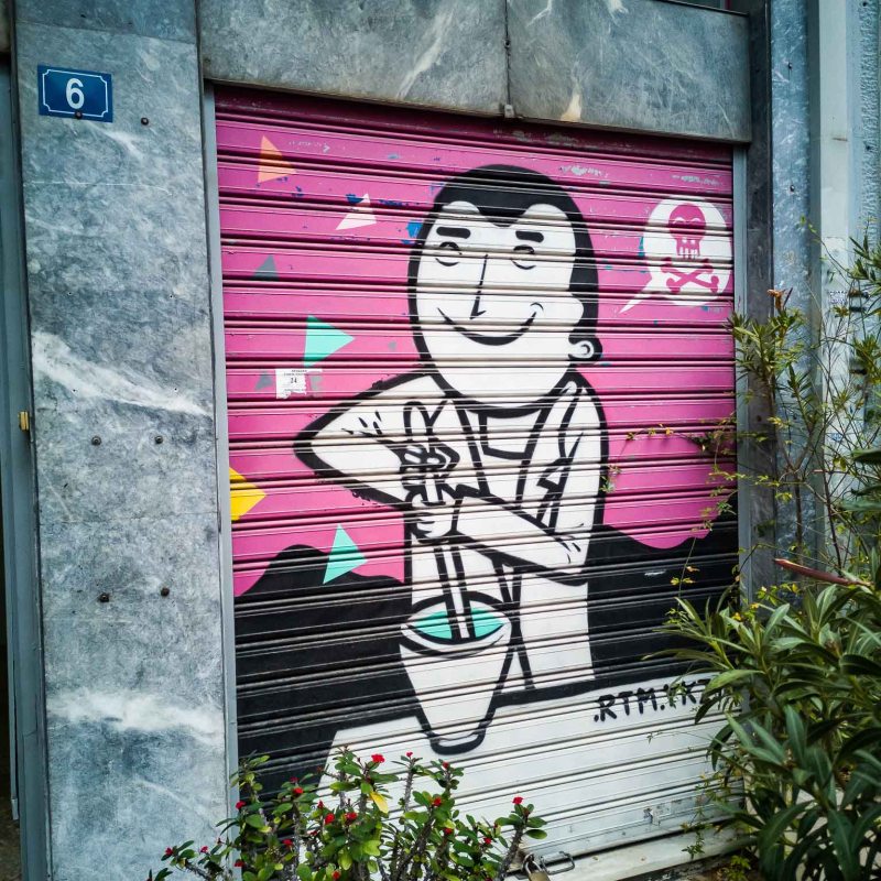 a person standing in front of a graffiti covered building