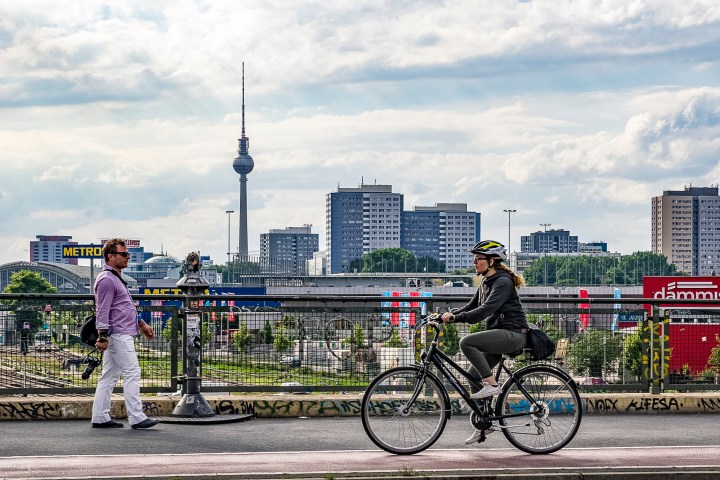 A biker passing the Warschauer Brücke in Berlin, with the Fernsehturm in the back