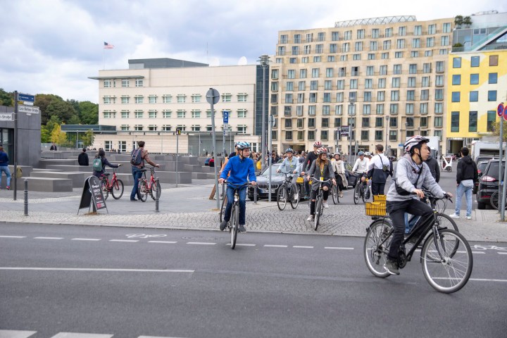 a group of people riding bikes on a city street