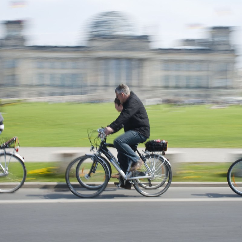 a group of people riding on the back of a bicycle