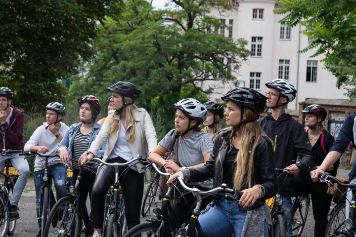 a group of people riding on the back of a bicycle