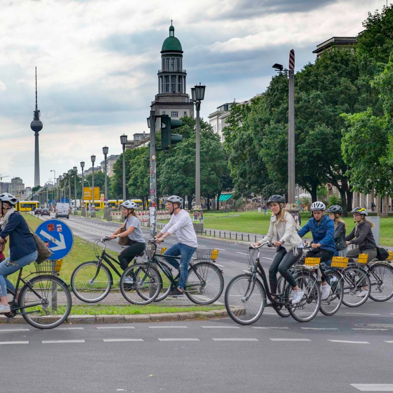 a group of people riding on the back of a bicycle