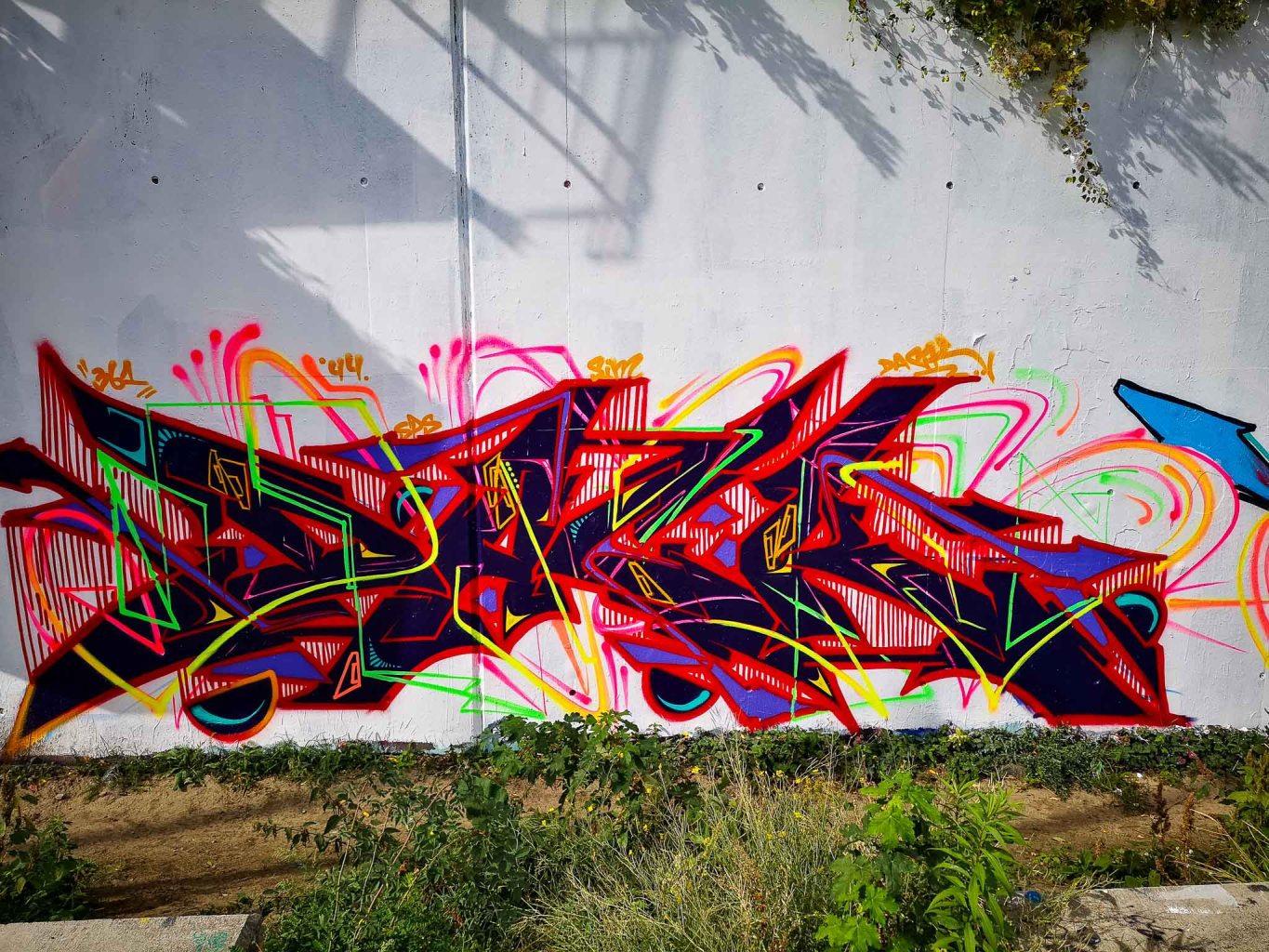 a colorful kite in front of a graffiti covered wall