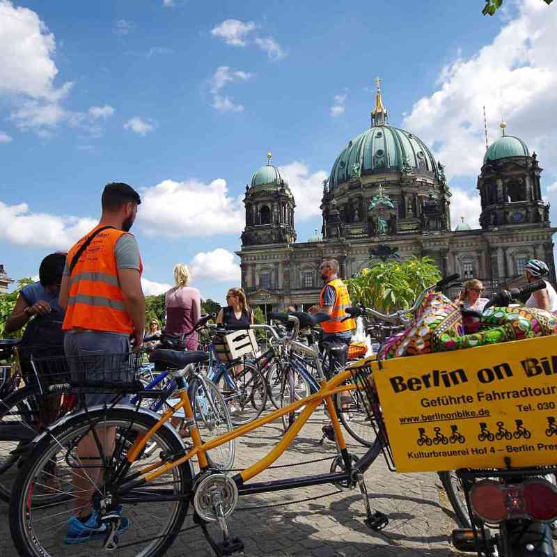 a group of people riding on the back of a bicycle