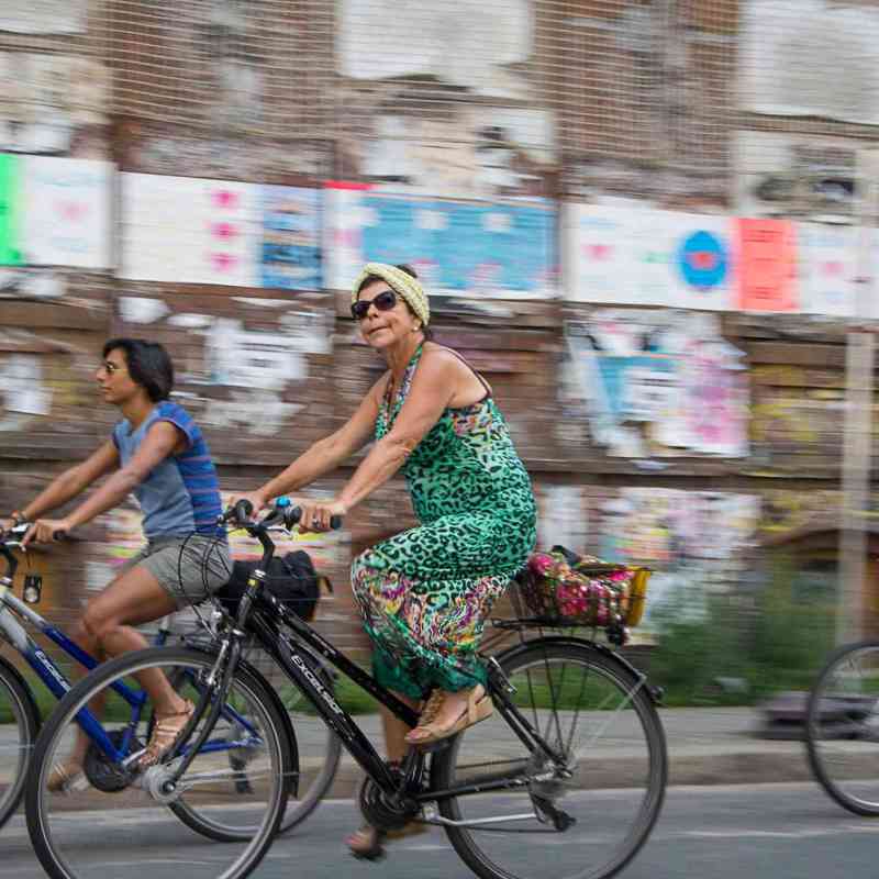 a woman riding on the back of a bicycle