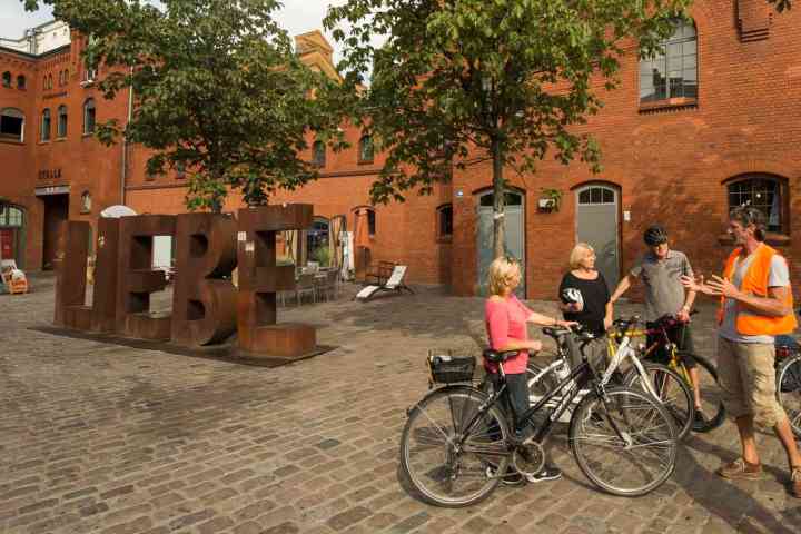 a group of people on a bicycle in front of a building