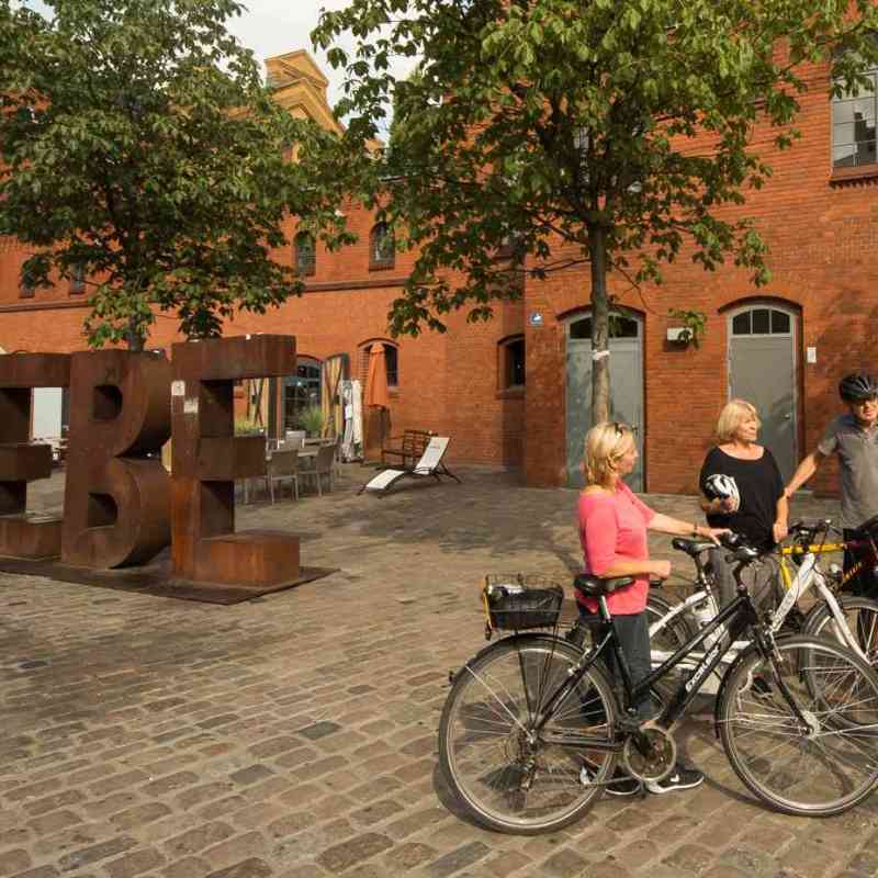 a group of people on a bicycle in front of a building