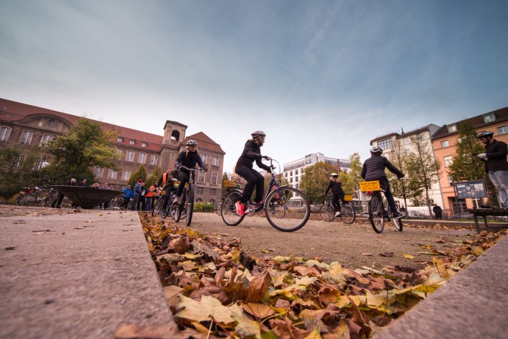 a group of people riding on the back of a bicycle
