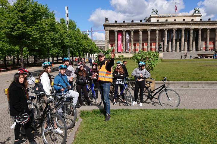 a group of people riding on the back of a bicycle