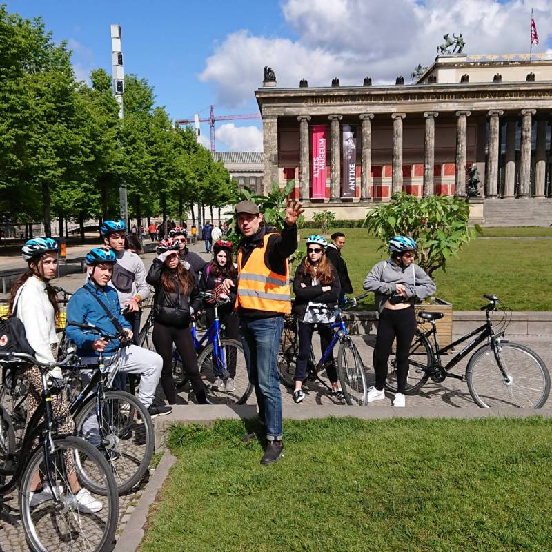a group of people riding on the back of a bicycle