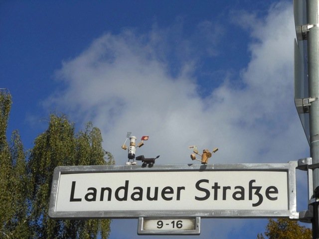 Korkmännchen Koch auf einem Berliner Straßenschild Korkmännchen Koch auf dem Schild