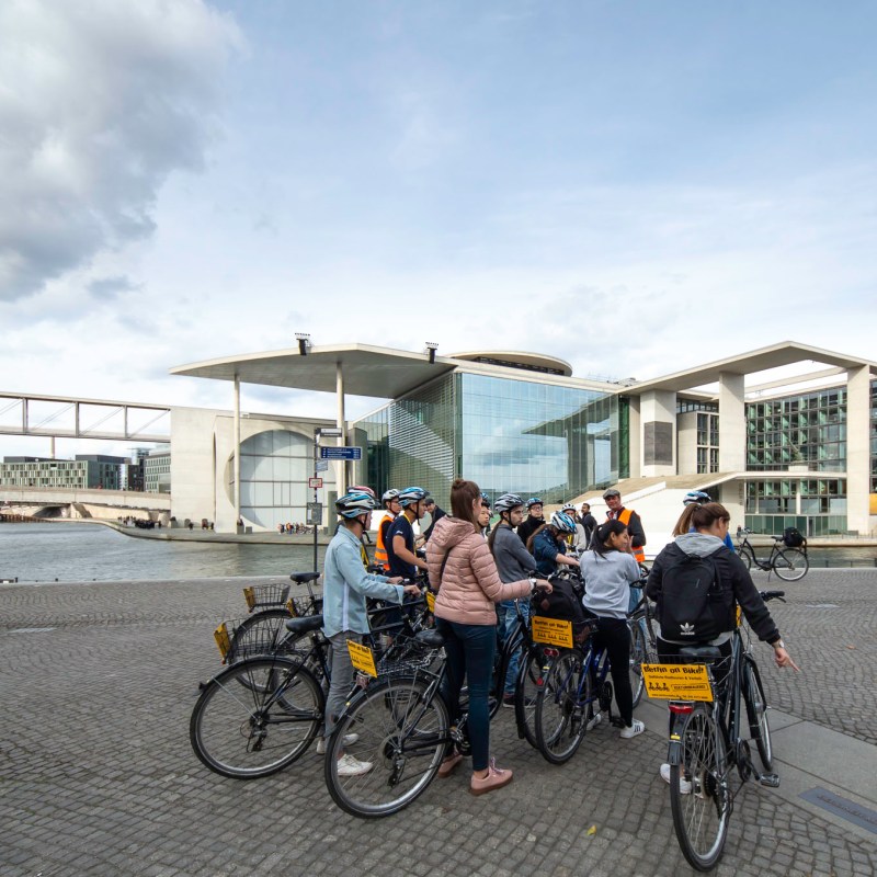 a group of people riding on the back of a bicycle