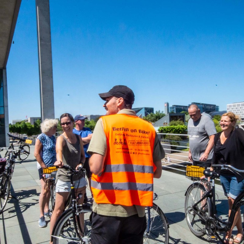 a group of people riding on the back of a bicycle