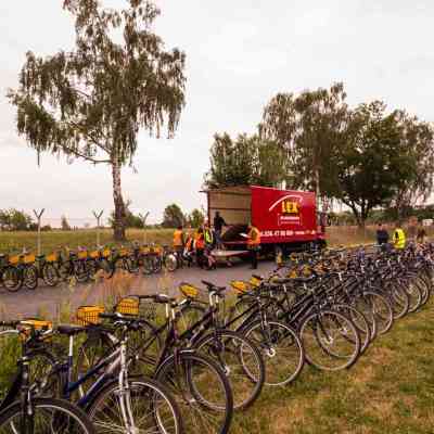 a row of bikes parked next to a fence