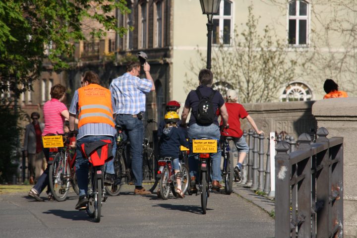 a group of people riding on the back of a bicycle