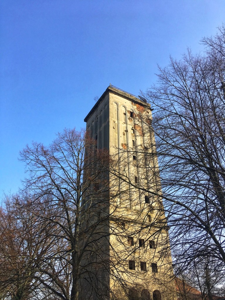 Der weithin sichtbare Wasserturm Heinersdorf sieht schon arg mitgenommen, nicht nur die Fassade bröckelt, auch das Innere ist seit einem Brand 2014 zerstört. Die eckige Form des Turms ist für einen Wasserturm ziemlich ungewöhnlich.