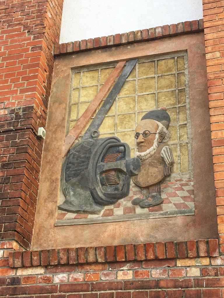 Dieses Relief an der Fassade des Motorwerks soll den Maler Adolph von Menzel darstellen, der als Maler Preußens bekannt wurde.