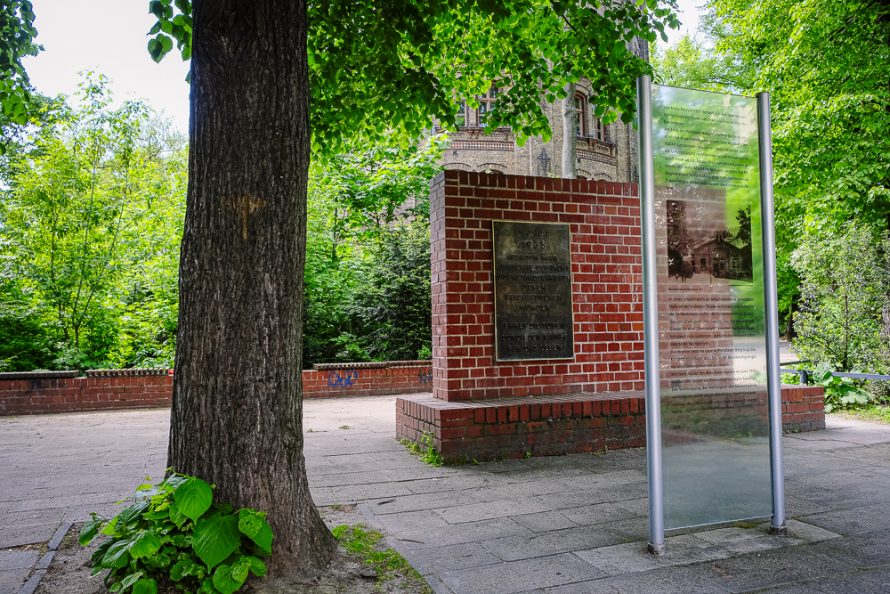 a tree in front of a brick building