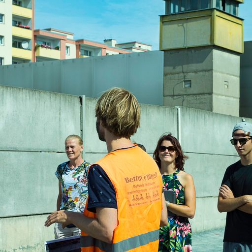 Guide mit Gruppe an der Mauergedenkstätte mit Wachturm