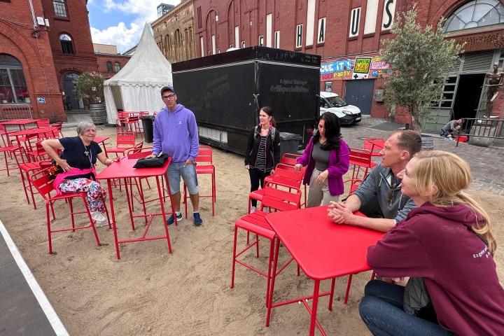 a group of people sitting at a table in front of a building