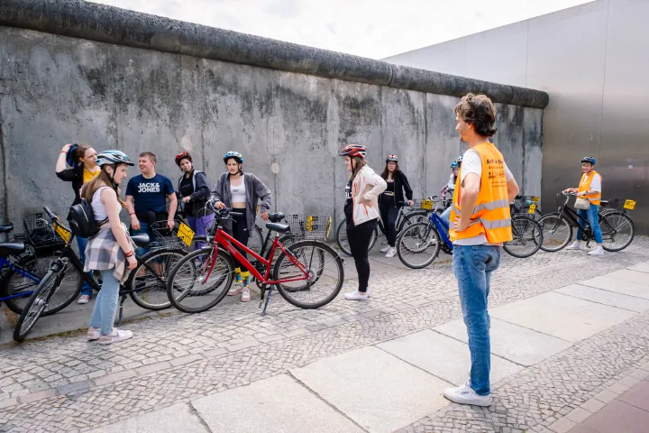 a group of people standing next to a bicycle