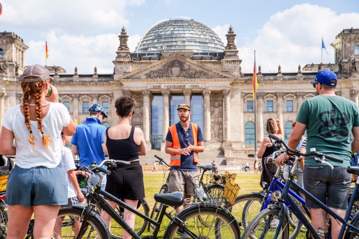 a group of people standing in front of a bicycle