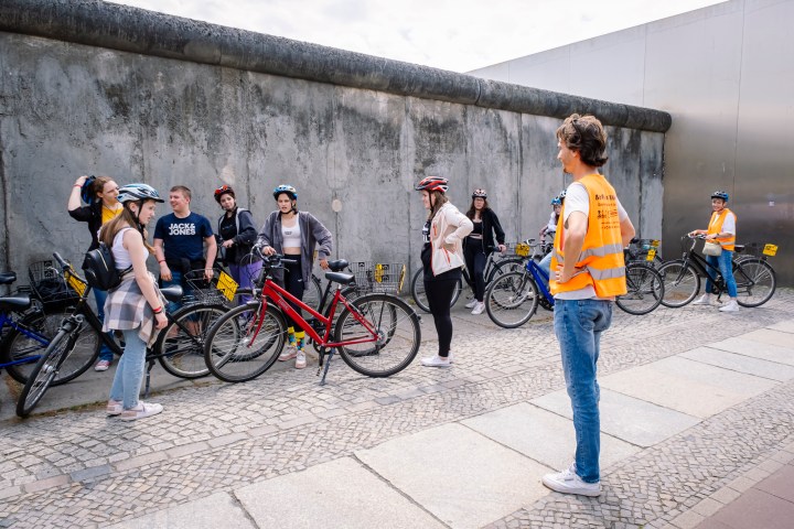a group of people standing next to a bicycle