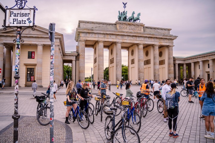 a group of people on a bicycle in front of a building