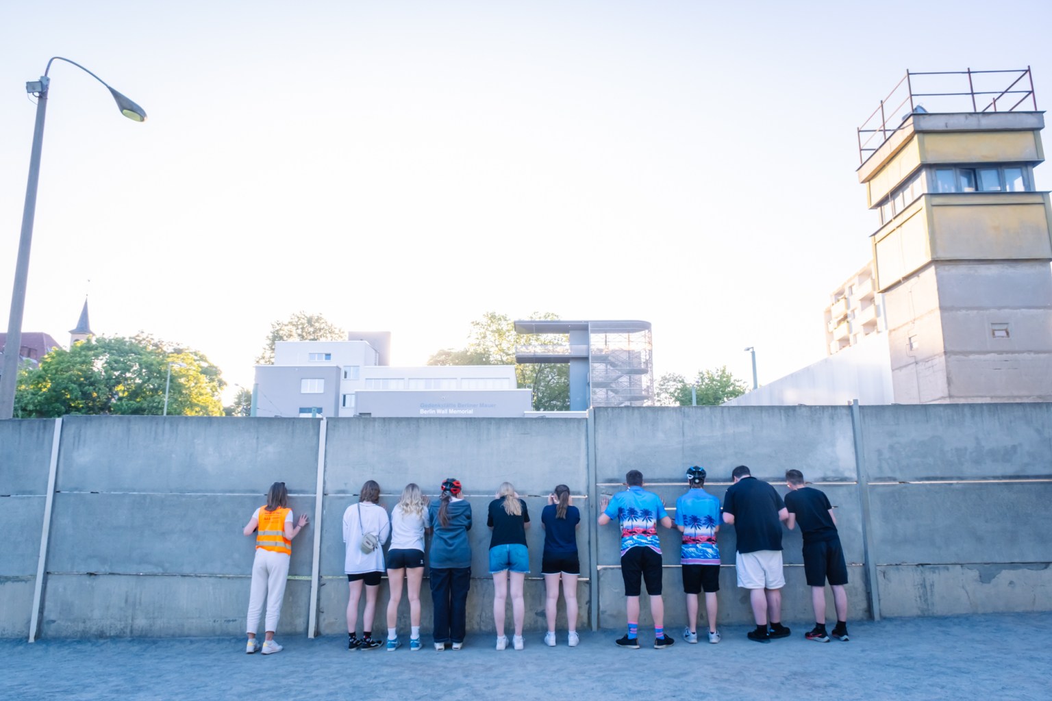 eine Gruppe Gäste schaut durch die Mauer an der Mauergedenkstätte Bernauer Straße