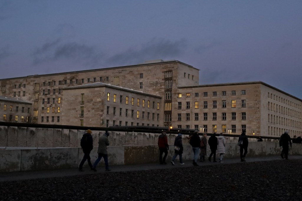 Gruppe läuft an den Resten der Berliner Mauer an der Topographie des Terrors entlang