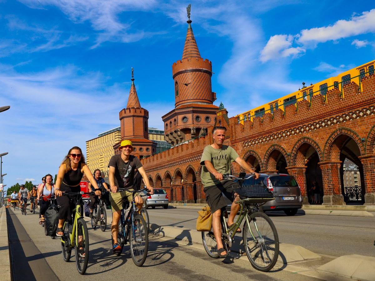 Radfahrende und Oberbaumbrücke-2 a group of people riding on the back of a bicycle