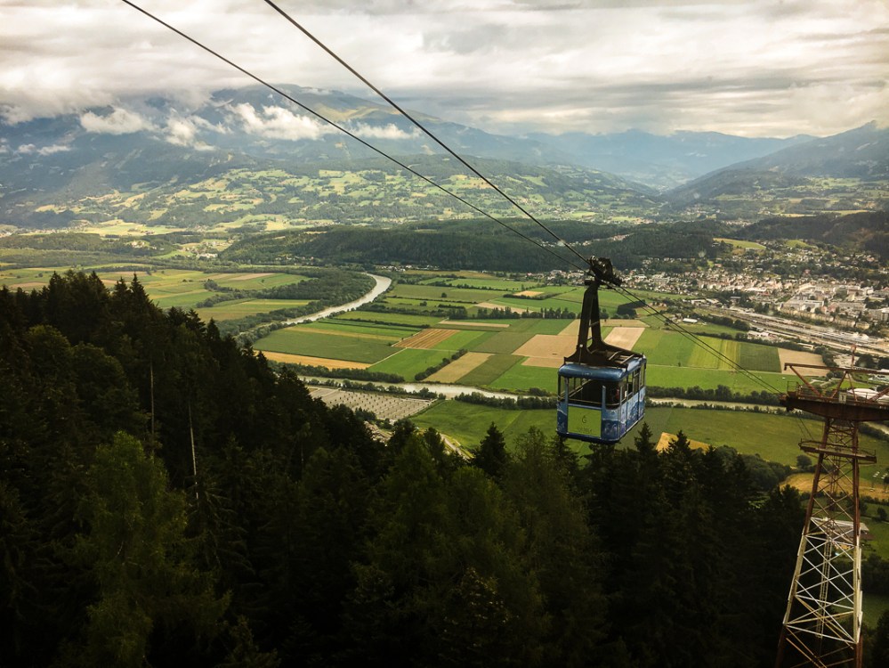 Blick einer Seilbahn-Gondel über ein Tal